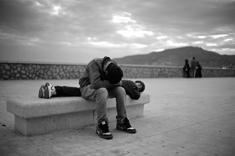 Karfreitag. Nach der Prozession in Trapani - Jungen schlafen erschöpft auf einer Bank an der Hafenpromenade.